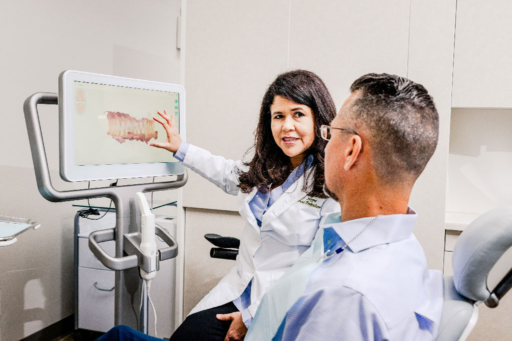 Dr. Pate, a Bentonville dentist, showing a patient digital x-rays before dentures