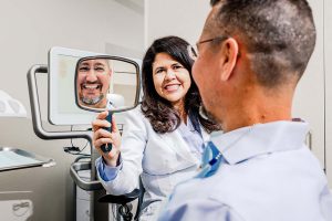 cosmetic dentist showing patient their porcelain veneers in bentonville ar