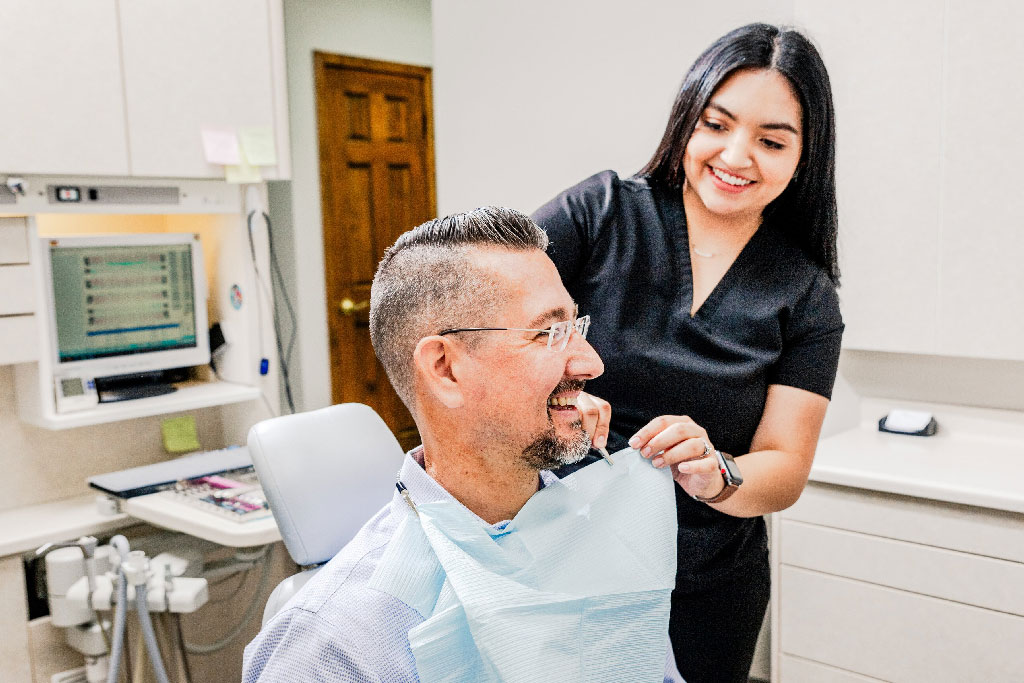 Dental assistant talking to a patient about our wide range of Bentonville dental services.